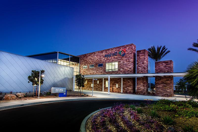 Exterior photo of 加州质子癌治疗中心 at dusk of entrance drive and landscaping.